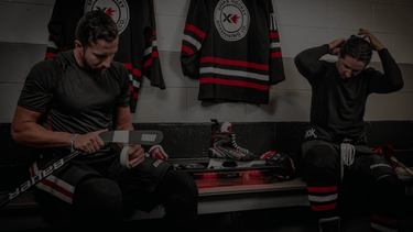 Hockey Player Taping their Hockey Stick while the Sparx ES200 Sharpener Sharpens their Skates